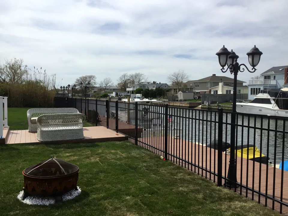 Four-foot black aluminum fence installed along a waterfront bulkhead in Mastic Beach, New York.
