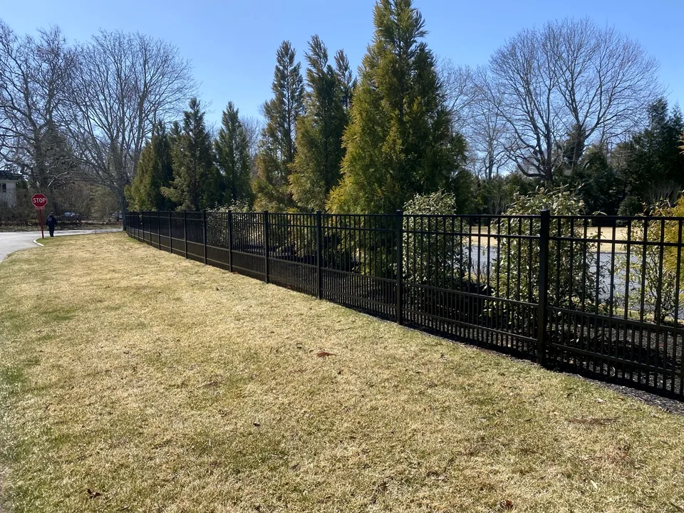 Four-foot black aluminum estate fence with puppy pickets extending along a landscaped Remsenburg, New York property.