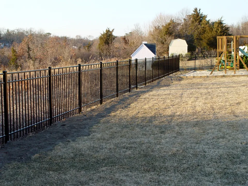 Long perspective of a four-foot black aluminum perimeter fence in Center Moriches, New York.
