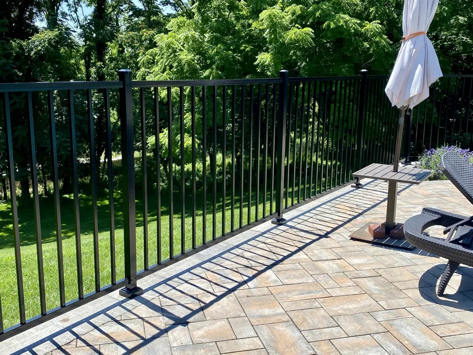 Four-foot black aluminum fence along the edge of a raised patio in Miller Place, New York.