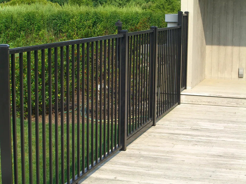 Four-foot black aluminum fence extending along the side of a wood deck in Southampton, New York.