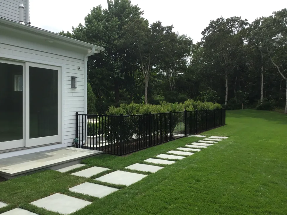 Four-foot black aluminum fence defining a landscaped garden area in Southampton, New York.