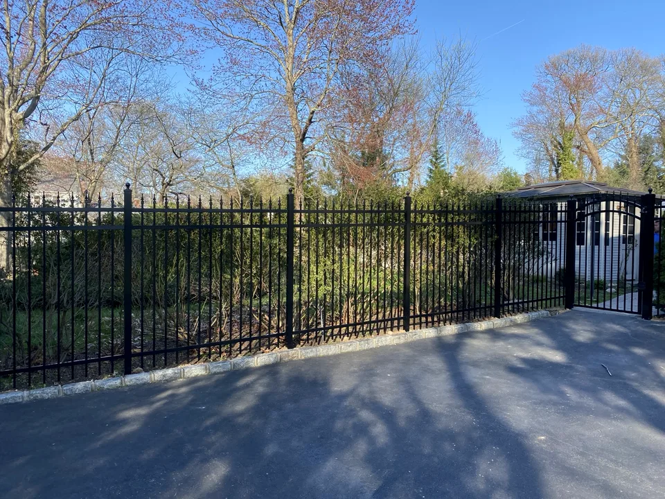 Wide view of a six-foot black Jerith aluminum Estate fence and arched gate in Mount Sinai, New York.