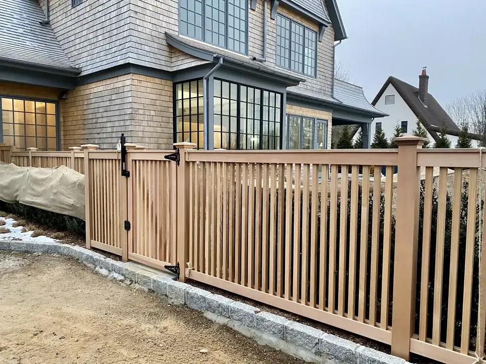 Clear cedar fence maintaining an intentional level top line beside a Southampton home