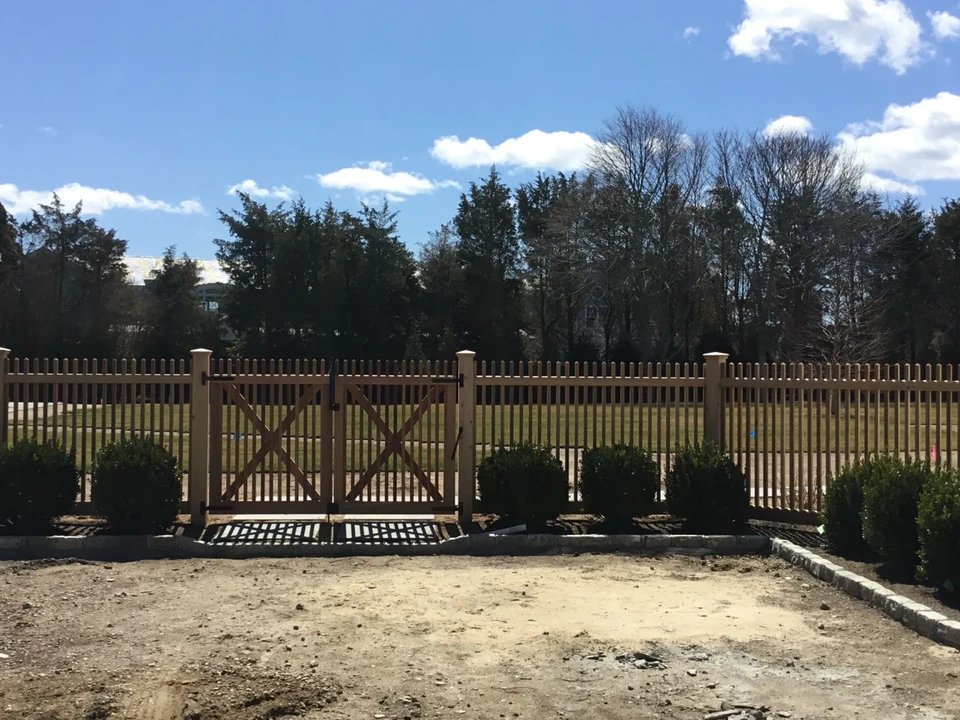 Wide property view of custom cedar fencing and double gate in Southampton, NY