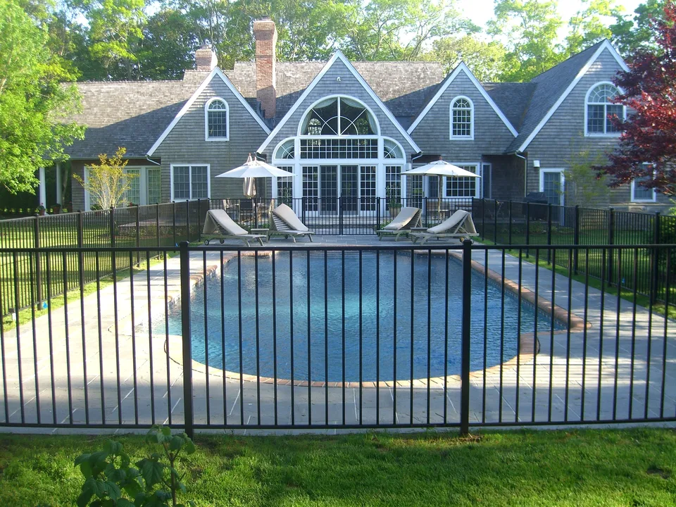 Black aluminum gate within a four-foot pool fence in East Hampton, New York.