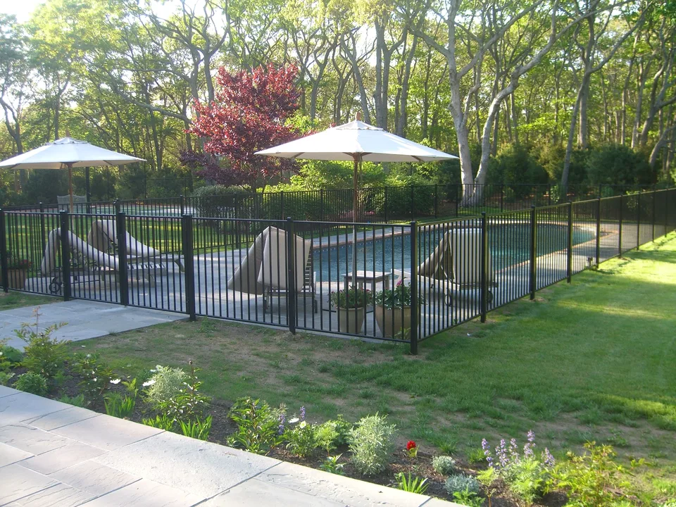 Four-foot black aluminum pool fence integrated with residential landscaping in East Hampton, New York.