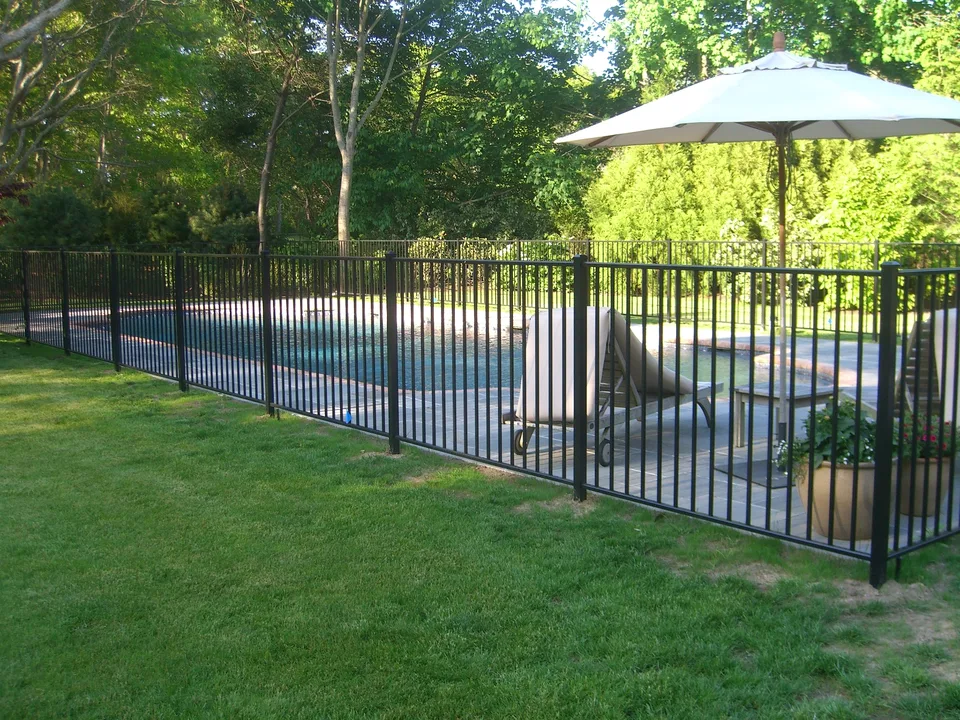 Four-foot black aluminum pool fence surrounding a residential pool in East Hampton, New York.