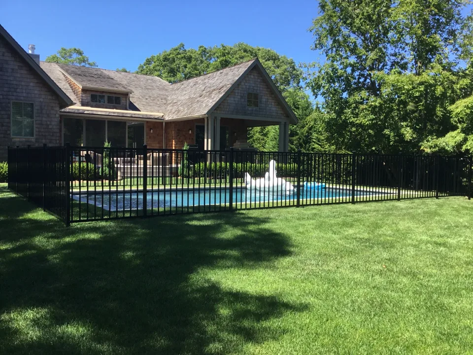 Black aluminum gate within a four-foot pool enclosure in The Springs, East Hampton, New York.