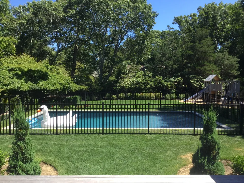 Four-foot black aluminum fence defining a residential pool perimeter in The Springs, East Hampton, New York.