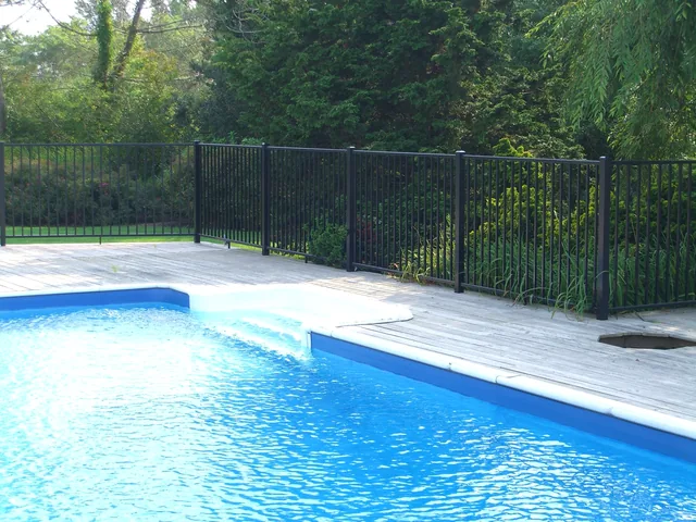 Black aluminum pool fence installation on a wood deck in Southampton, New York