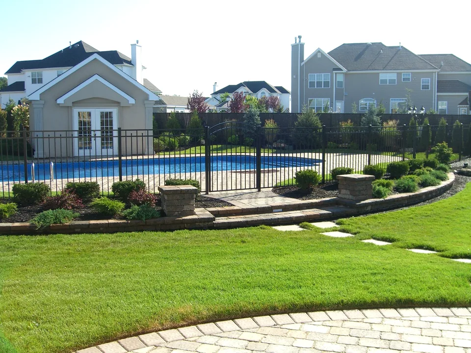54-inch black aluminum pool fence following the perimeter of an inground pool in Miller Place, New York.