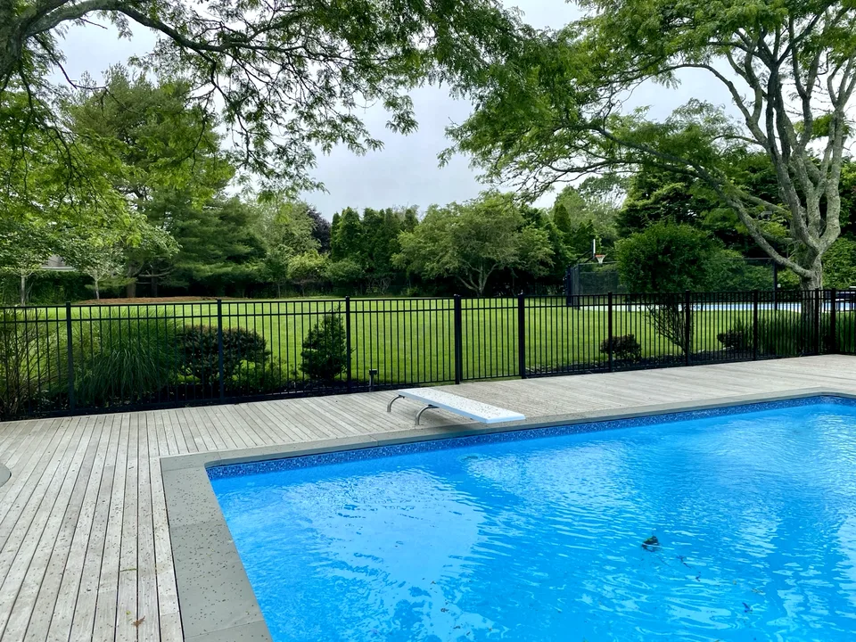 Fifty-four-inch black aluminum pool fence shown from inside the pool area in Remsenburg, New York.