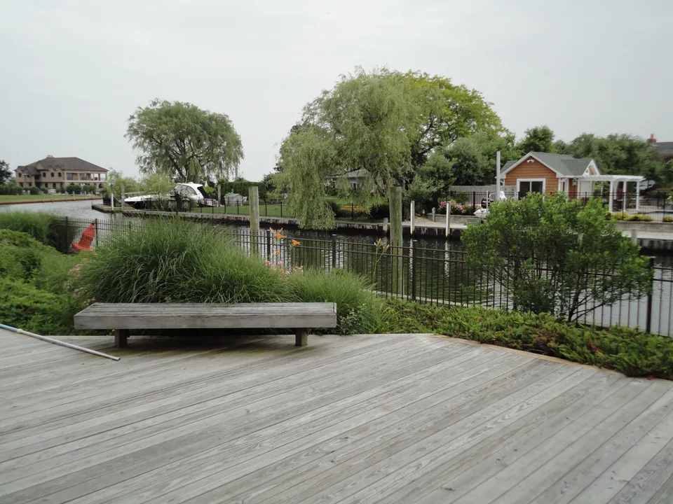 Aluminum waterfront fence integrated with mature landscaping in East Islip, New York