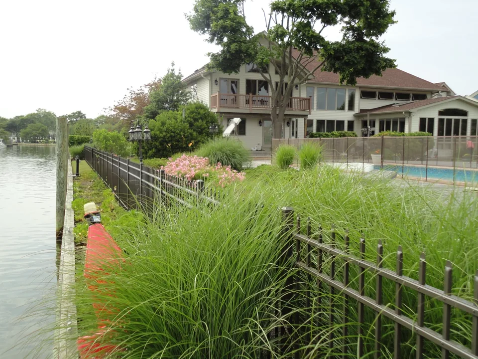 Aluminum estate fence along a landscaped waterfront property in East Islip, New York