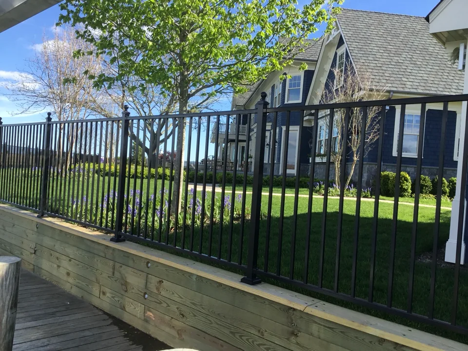 Black aluminum fence along a raised timber edge at an East Islip waterfront residence