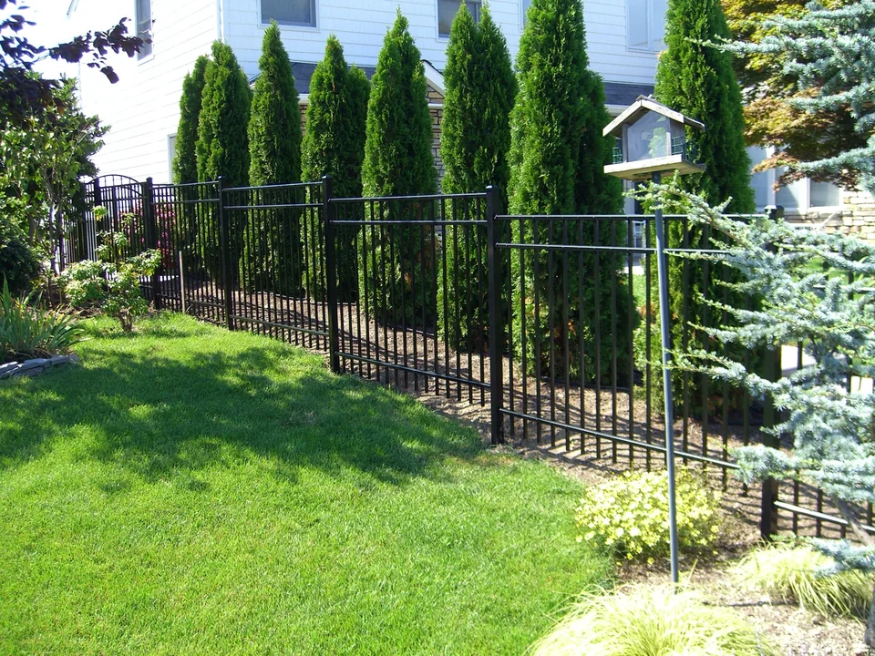 Black aluminum fence running through a landscaped side yard in Seaford, New York