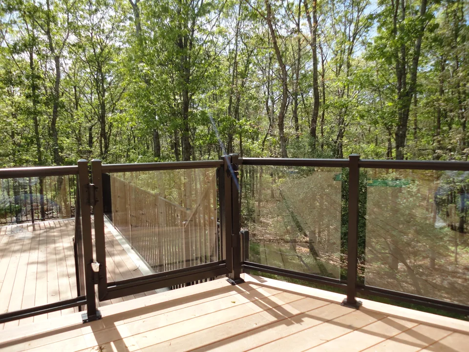 Custom aluminum-framed glass gate and corner transition on a wood deck in Southampton, New York