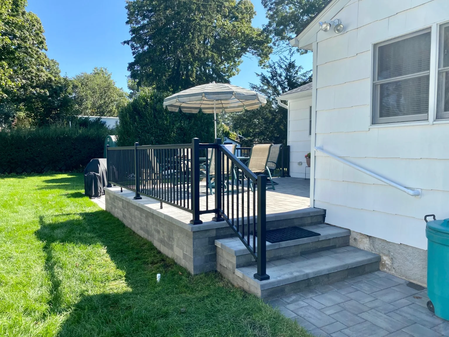 Black aluminum railing at the front stoop or backyard patio of a Bellport home