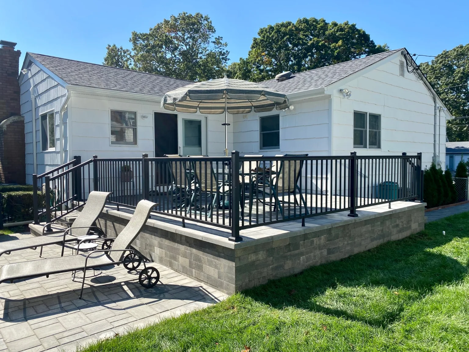 Black aluminum railing at the front stoop or backyard patio of a Bellport home