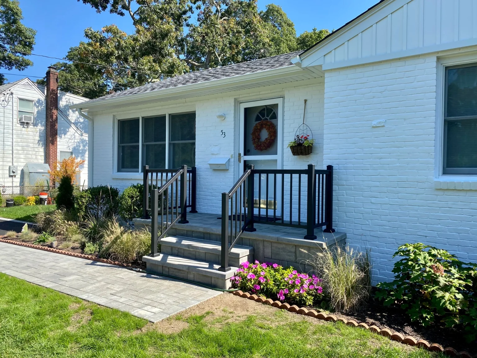 Black aluminum railing at the front stoop or backyard patio of a Bellport home