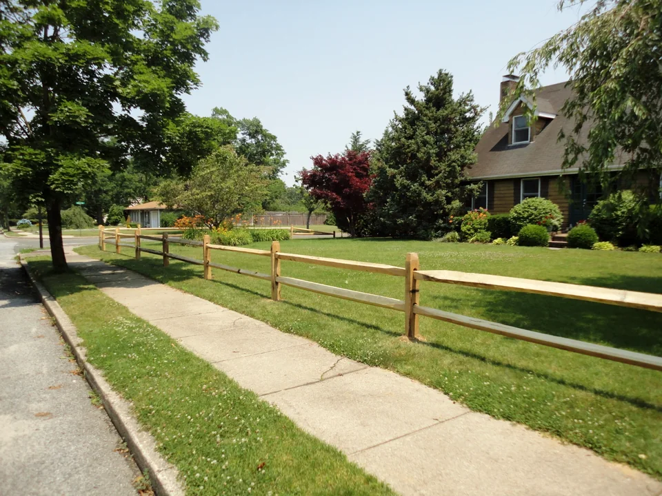 Two-rail split rail fence along a residential Bellport, New York property.