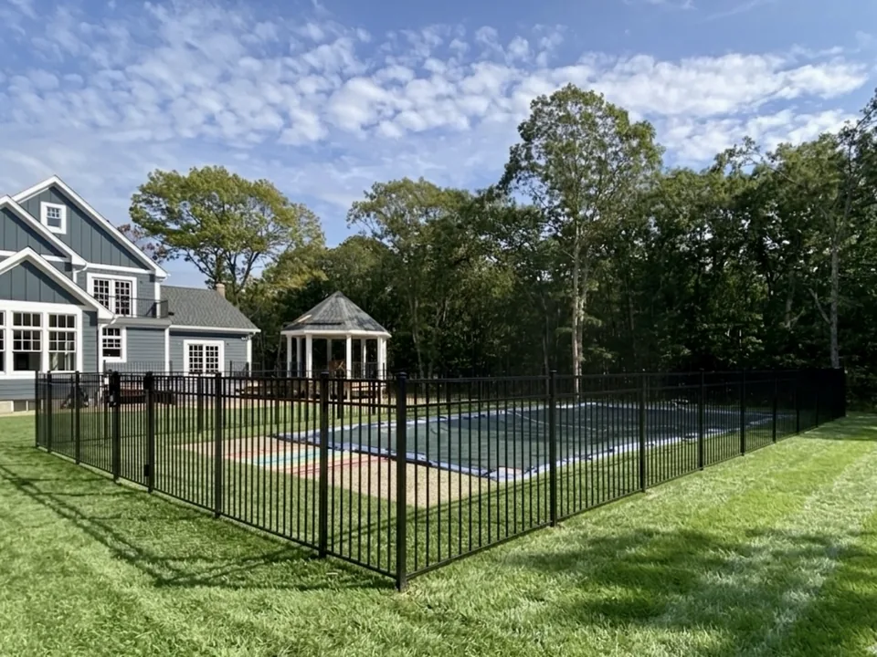 Fifty-four-inch black aluminum fence enclosing an inground pool, with a white gazebo and blue board-and-batten house beyond, in Manorville, New York