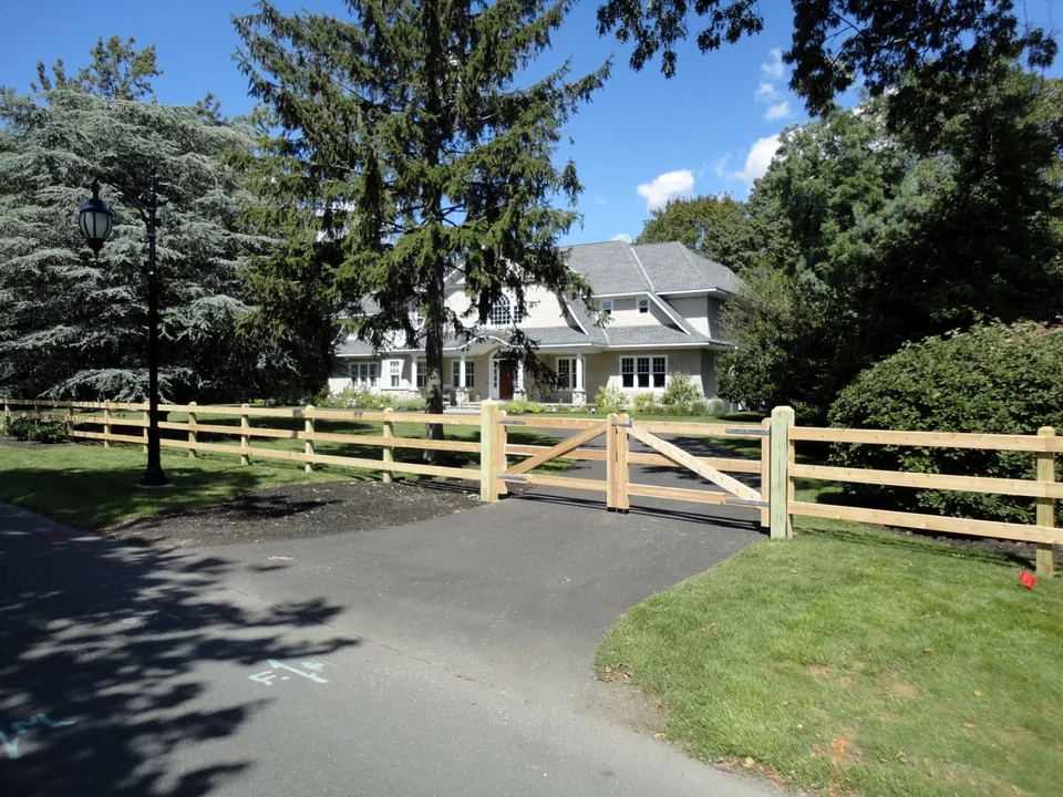 Cedar 3-rail board fence across a large residential property in Bay Shore, NY