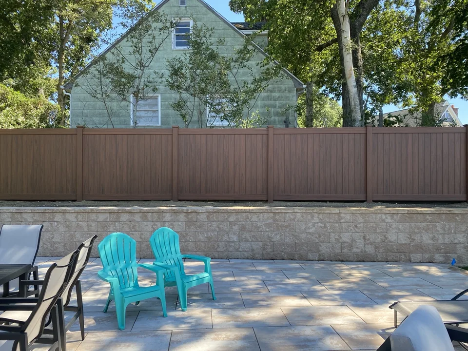Genuine finished Sag Harbor cedargrain PVC privacy fence photographed from the terrace after installation