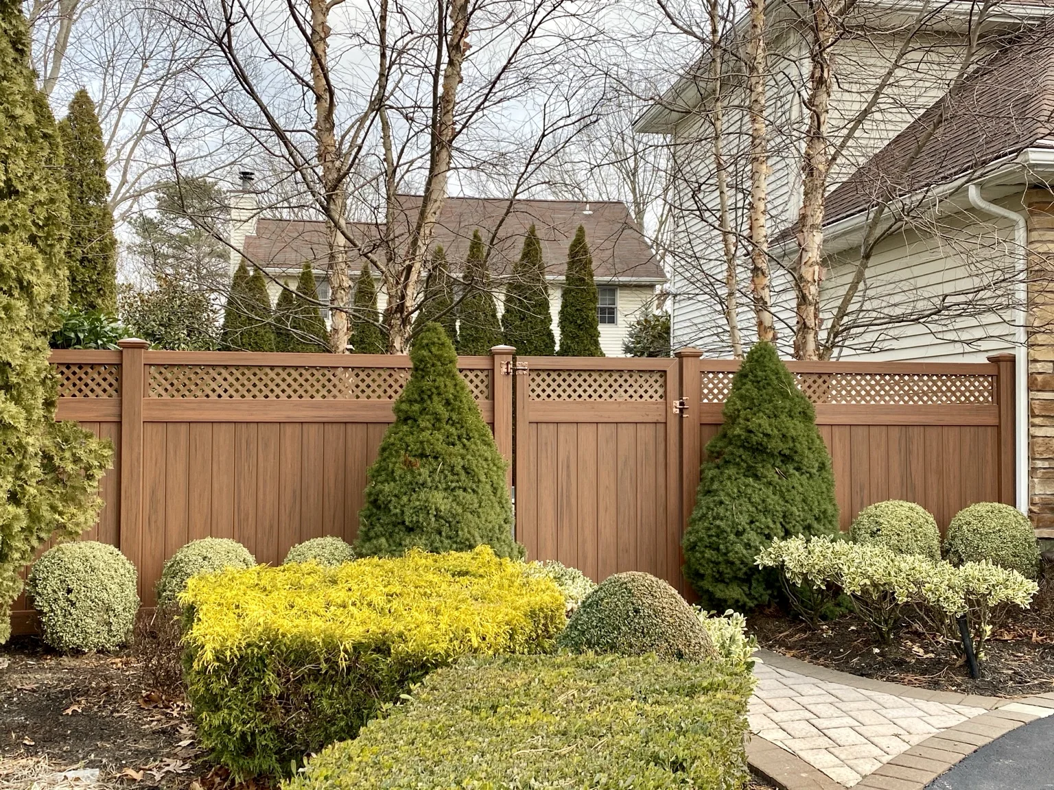 Cedargrain vinyl privacy fence coordinated with a West Islip home and landscaping