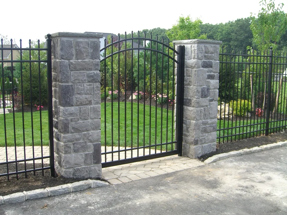 Alternate view of the arched aluminum gate between stone columns in Miller Place, New York