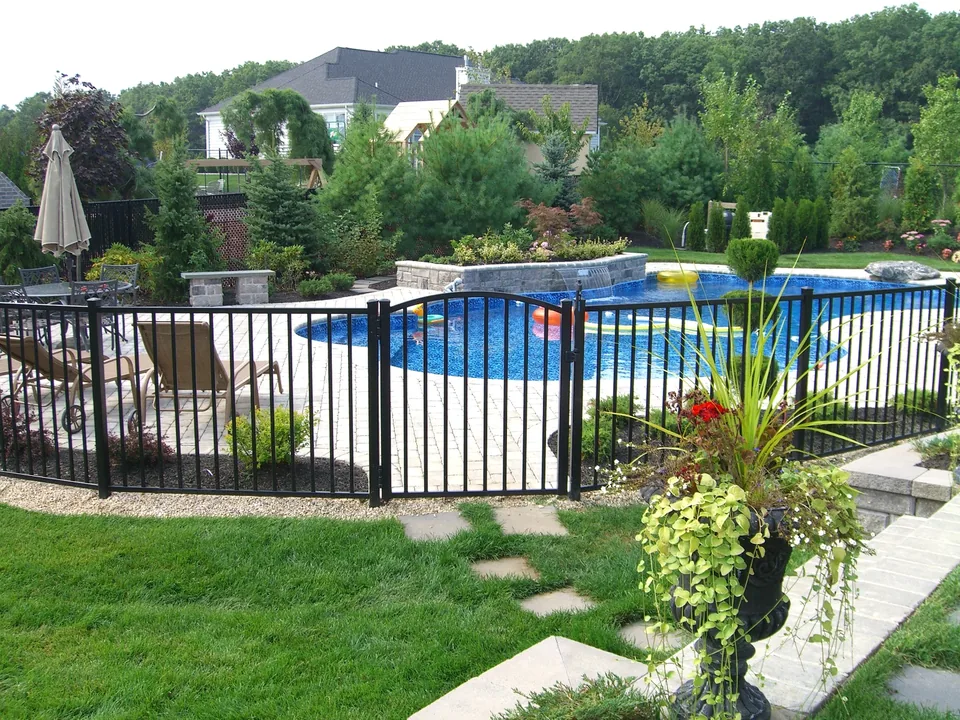 Black aluminum pool fence integrated with a landscaped backyard in Miller Place, New York