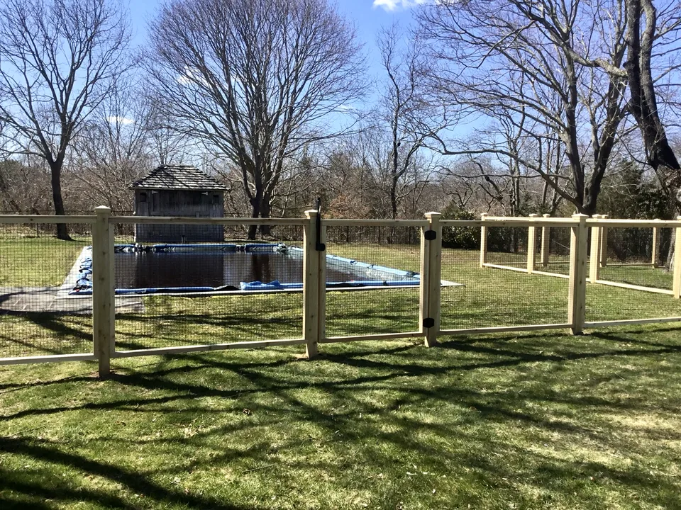 Custom cedar framed-wire pool gate opening away from the pool in Center Moriches, New York.