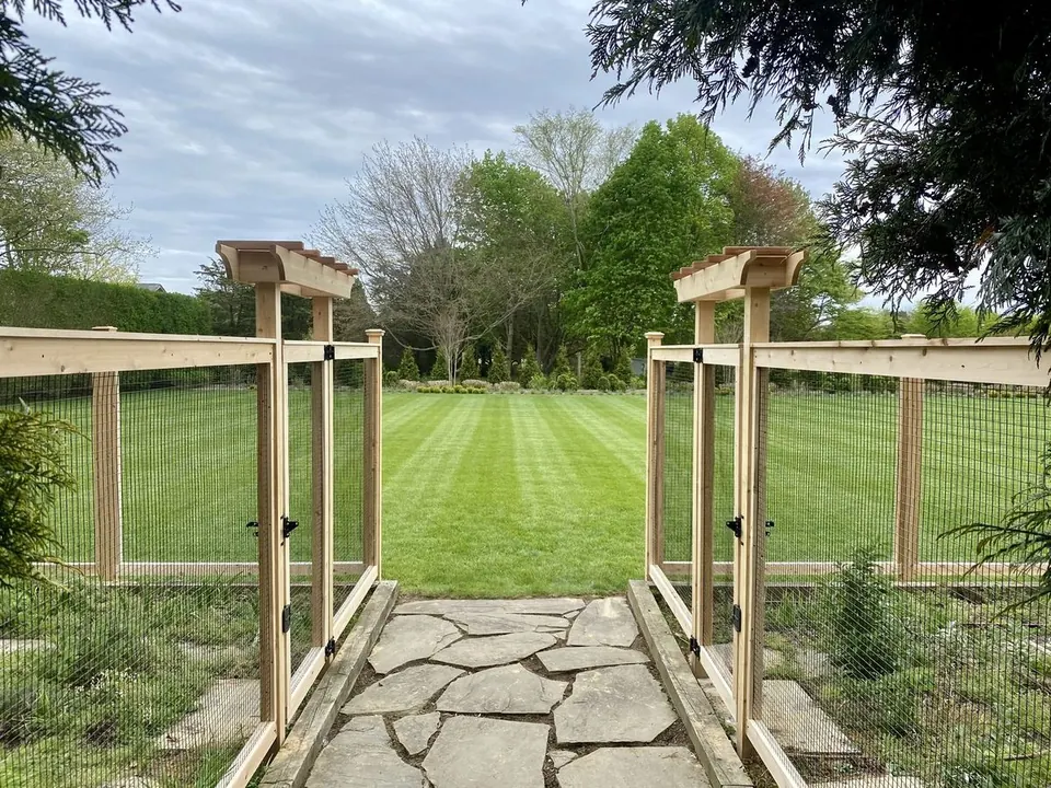 Custom cedar garden fence with arbor gates in Suffolk County