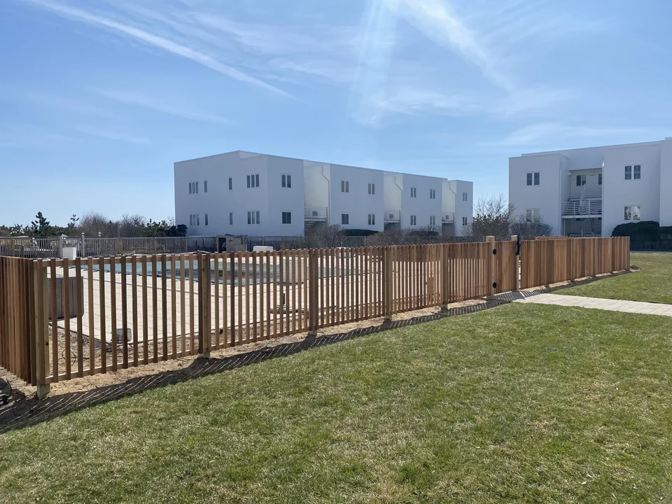 Wide view of custom cedar condominium pool fence in Montauk