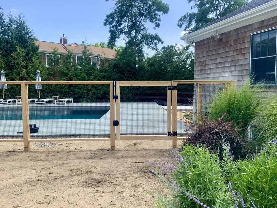 A custom cedar gate built into the fence line rather than added to it