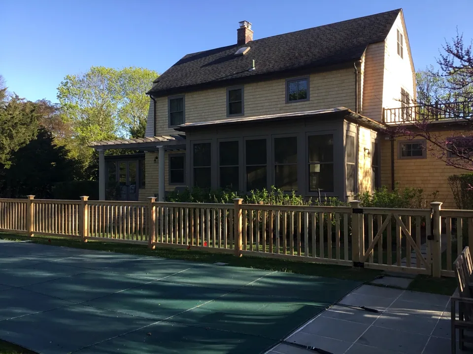 Custom white cedar fence and gate at a traditional Bellport Village residence