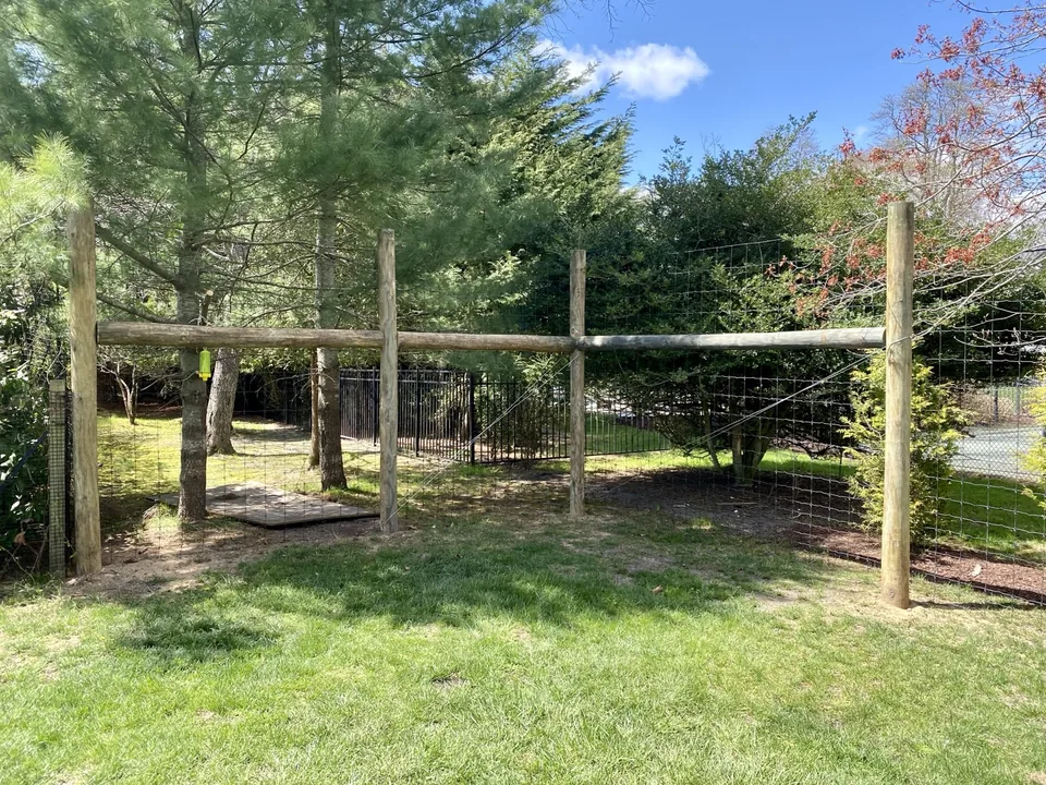 Braced rail and post detail where a round-post deer fence meets a property transition