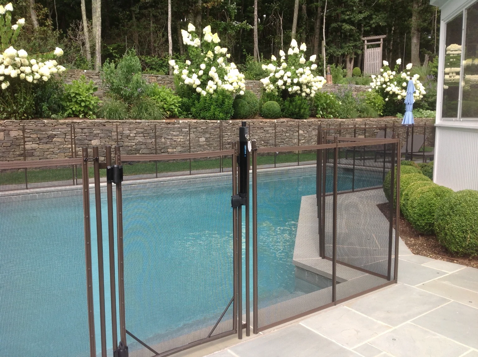 Brown Guardian removable mesh pool fence gate near the East Hampton home