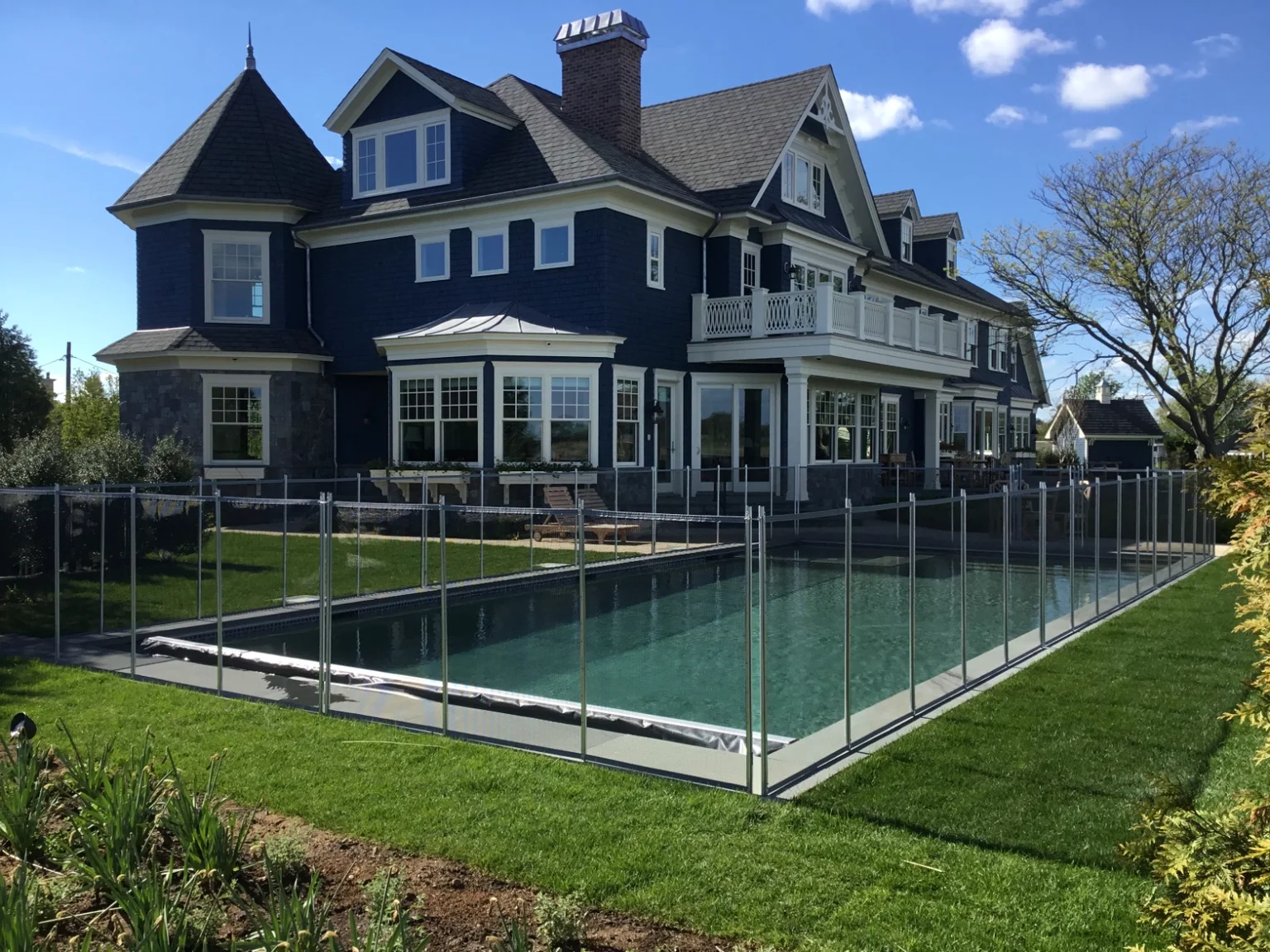 Guardian Vanishing pool fence surrounding a waterfront pool at a custom residence in The Moorings, East Islip, New York