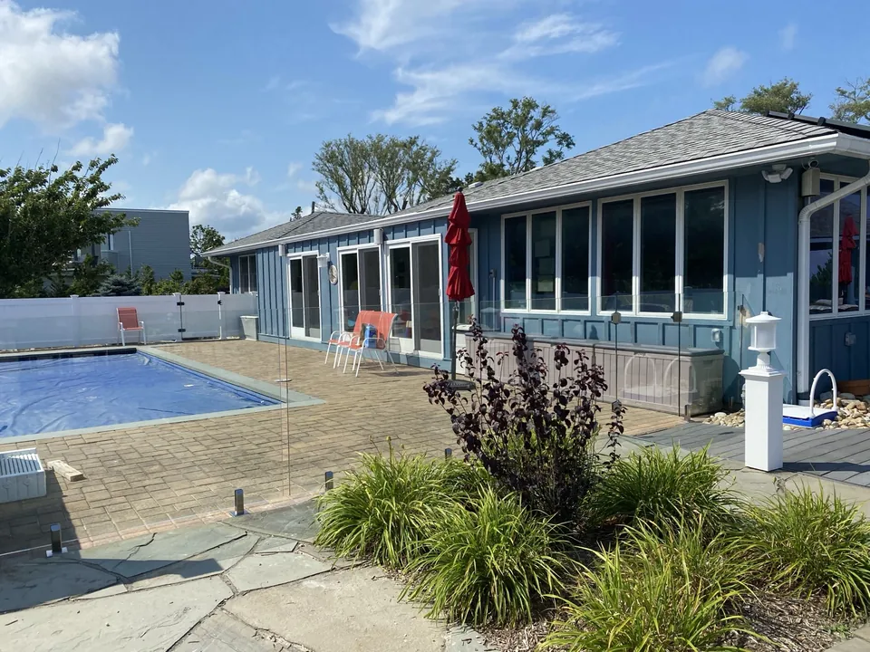 Tempered glass pool fence installed along a waterfront pool patio in Southold, New York.