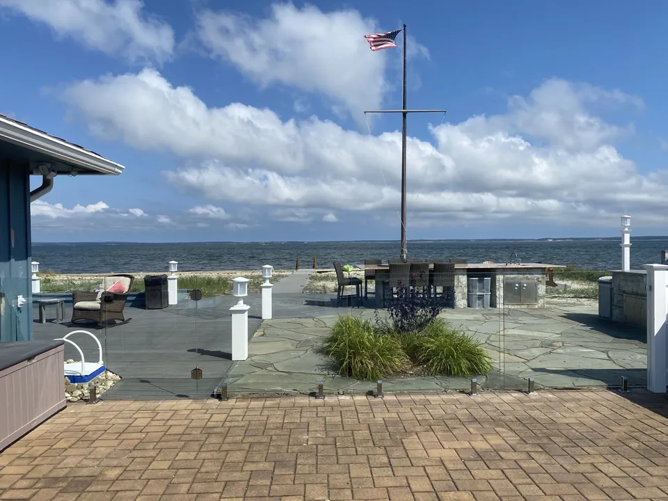 Frameless glass pool fence with an unobstructed water view in Southold, New York.
