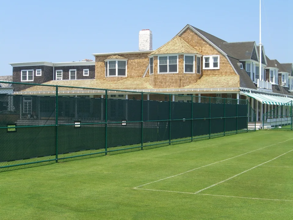 Green chain link tennis court enclosure at a private club in Southampton, New York