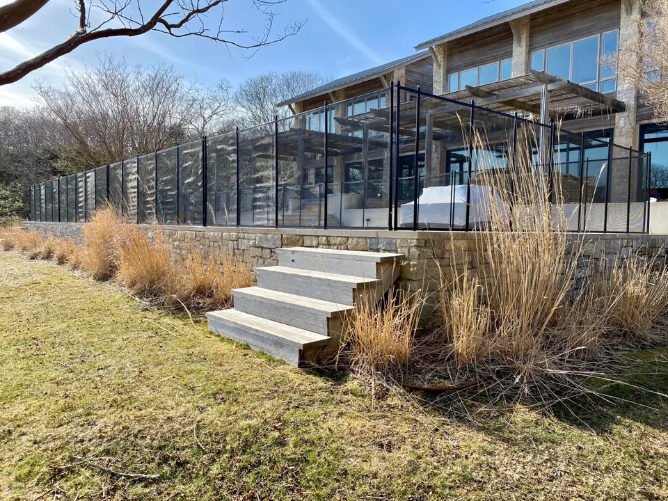 All-black Guardian pool fence integrated with the architecture and stone terrace in Montauk