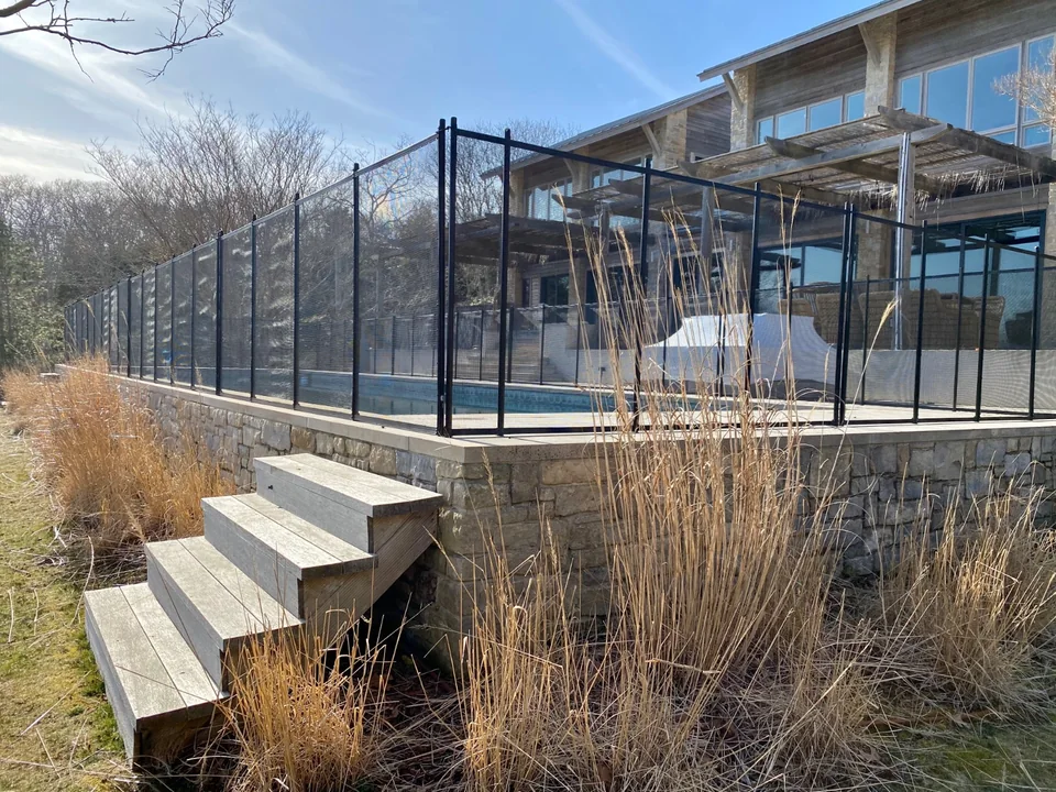 Guardian Premier black mesh pool fence viewed toward the Montauk home