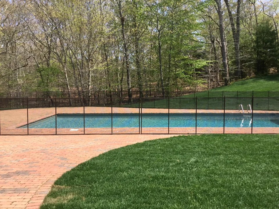 Brown Guardian Premier removable pool fence along the red brick patio in East Hampton New York
