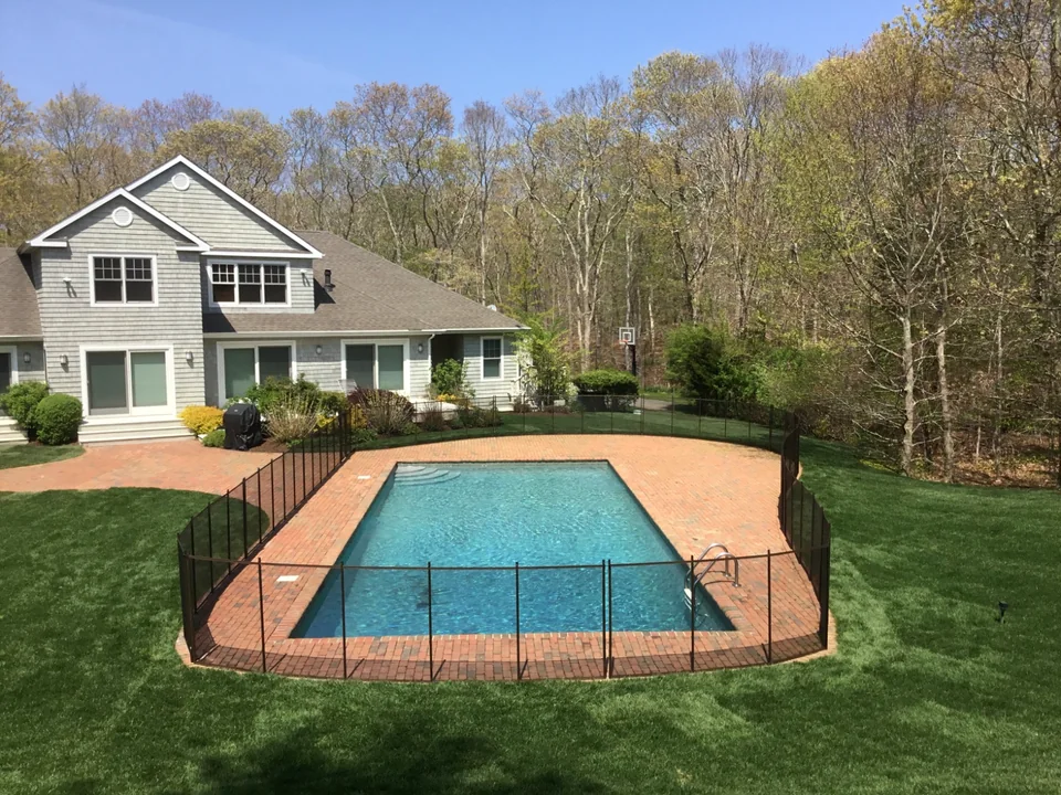 Guardian Premier brown removable pool fence viewed from the end of the swimming pool in East Hampton