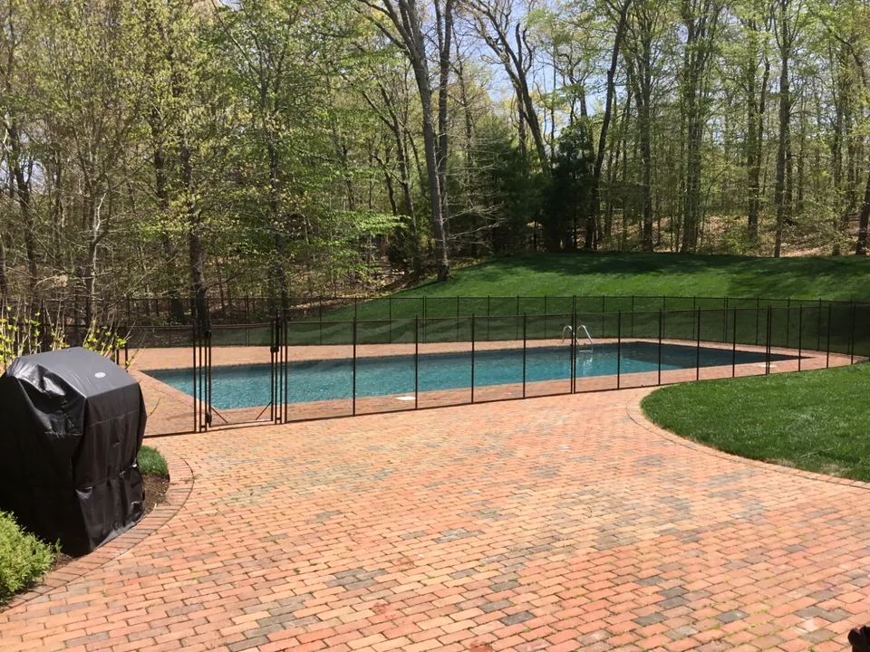 Brown Guardian Premier pool fence installed through a red brick pool patio in East Hampton New York