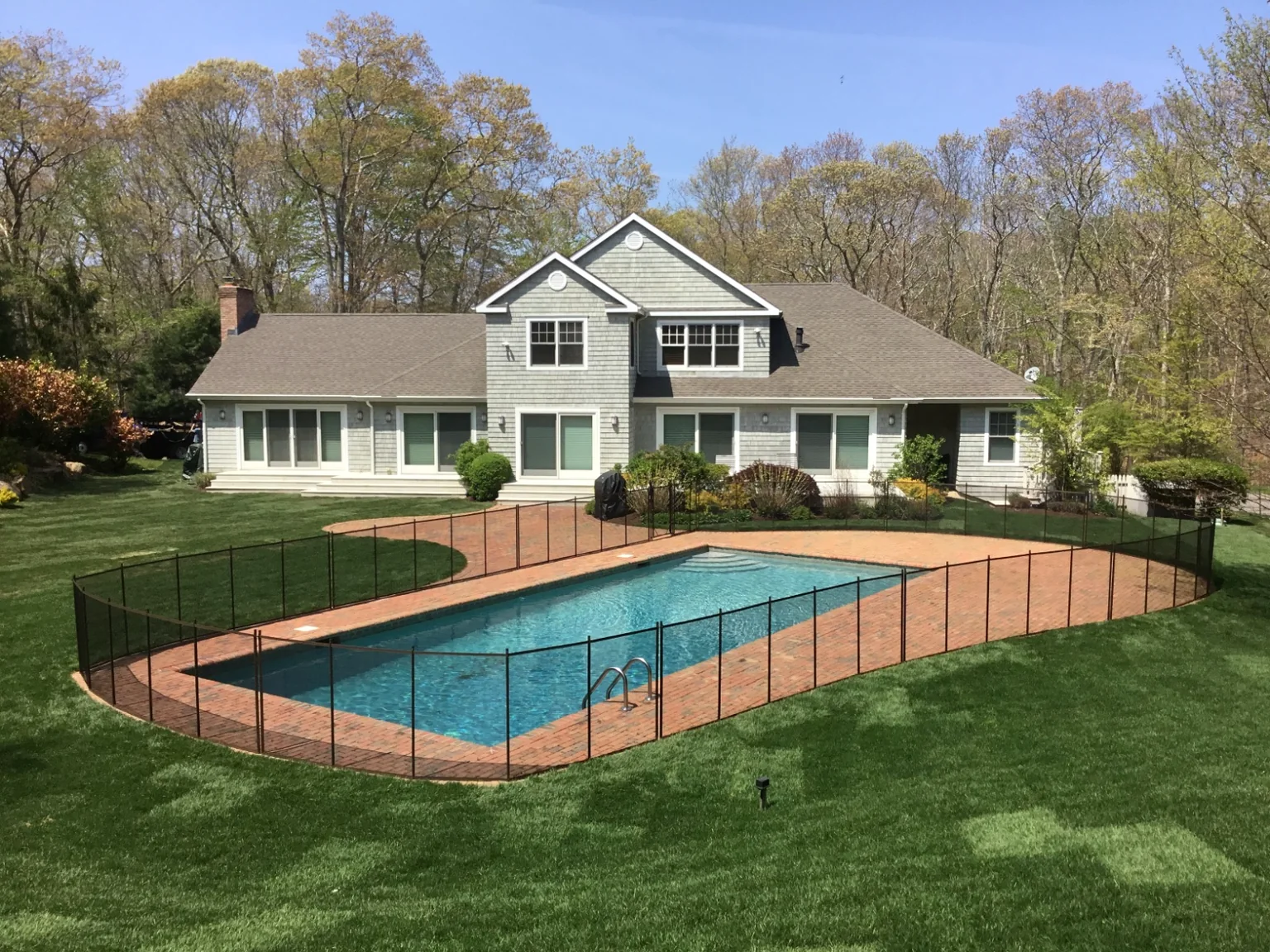 Guardian Premier brown removable pool fence with East Hampton home, red brick patio and swimming pool