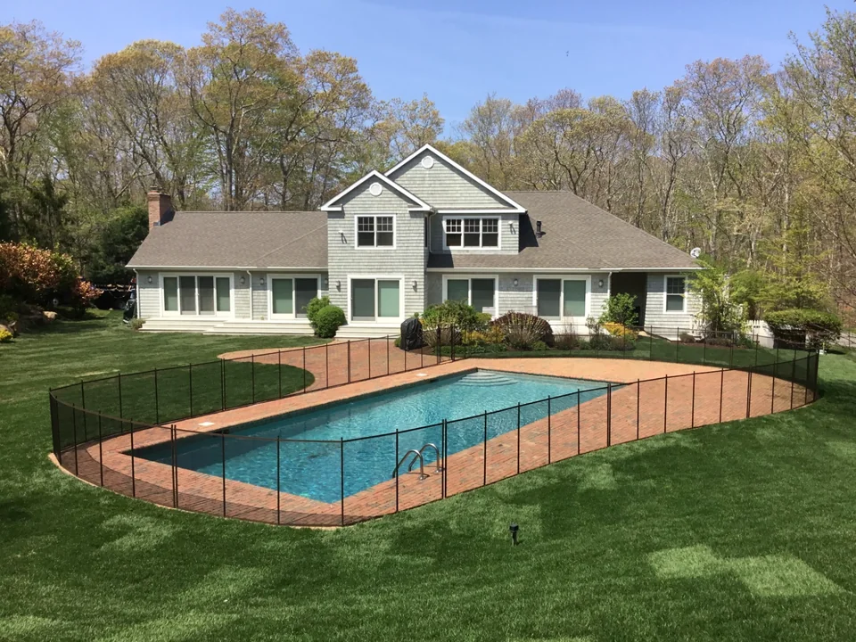 Guardian Premier brown removable pool fence with the East Hampton home, red brick patio and swimming pool